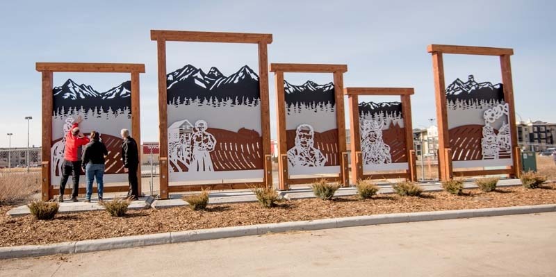 Coun. Tara McFadden and Mayor Ivan Brooker help Coun. Ross Watson see the new public art structure on Fourth Avenue in Cochrane on Friday, March 31, 2017. The art piece is