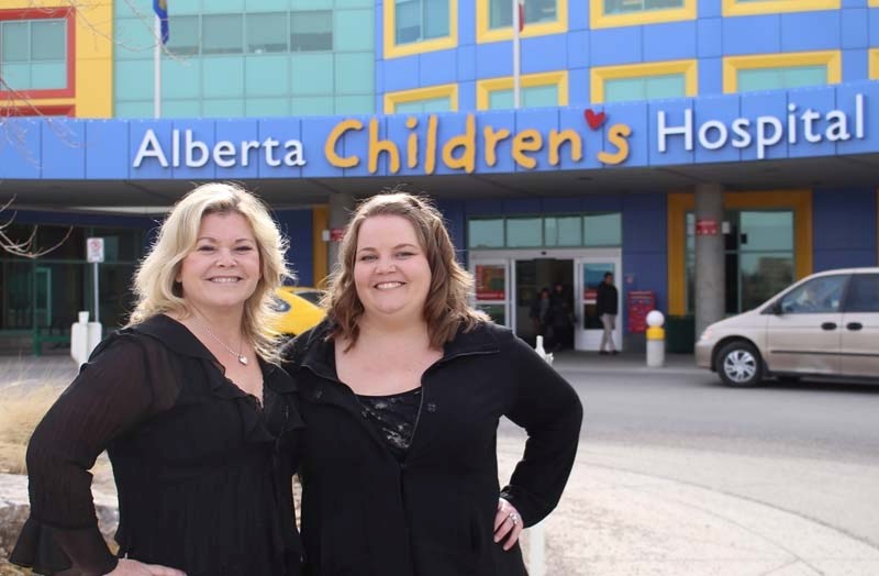 Robyn Carrier, left, and her daughter, Carie Stock, stand outside the Alberta Children&#8217;s Hospital in Calgary, Alberta on April 5. Stock is the founder and executive