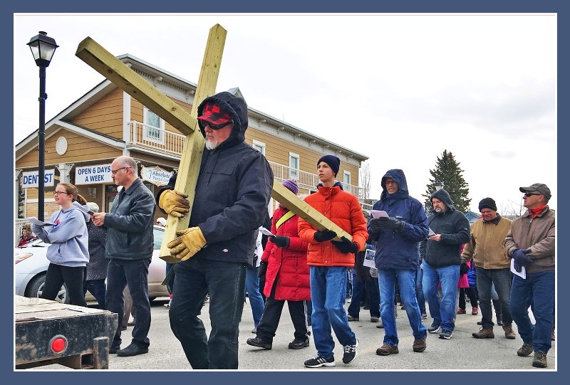 Tim Ellenbroek (left) and John Carvalho, representing St. Mary&#8217;s Parish, carry the cross at Cochrane&#8217;s interchurch Good Friday Walk of the Cross.