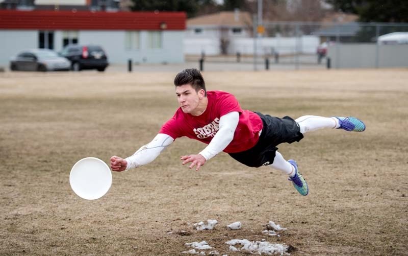 Jedediah Heal performs a layout, an ultimate frisbee move where the player launches into midair to catch the frisbee at the Cochran High School field in Cochrane on Saturday, 