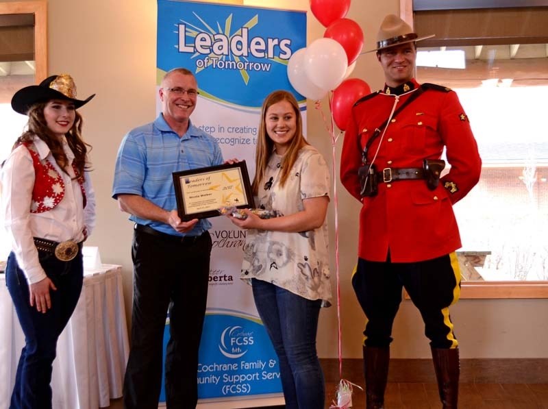 Nicola Walker accepting her award from Cochrane mayor Ivan Brooker and Cochrane Lions Rodeo Queen, Leah Jackson (left) and RCMP Constable Curtis Huculak (right) at the annual 