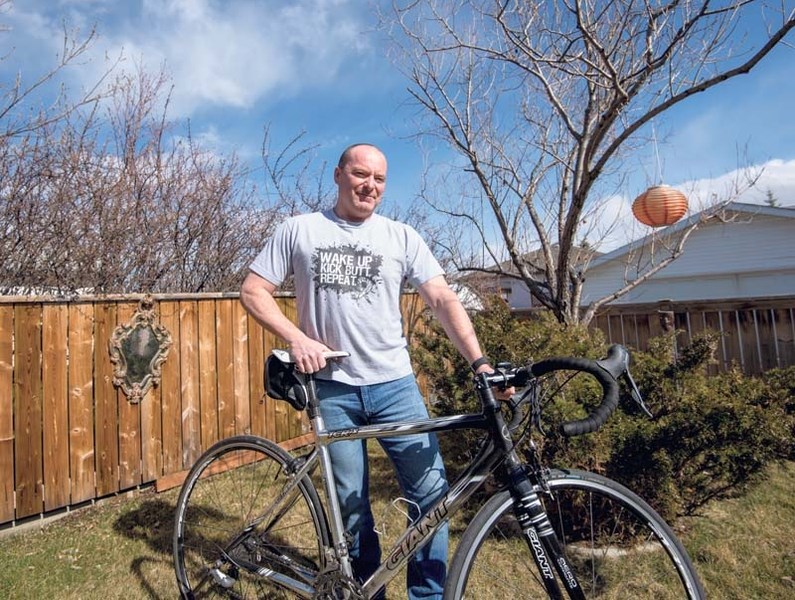 Rick Deans with his bicycle at his home in Cochrane on Tuesday, May 2.