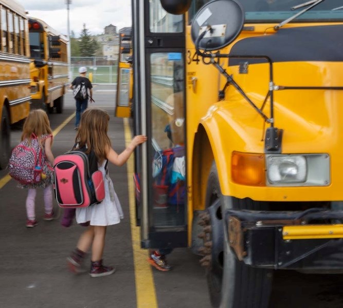 School kids rush to take the bus home from school on May 9.