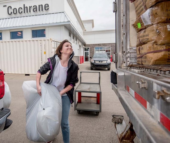 Bow Valley High School Grade 10 student, Arena Anderson, volunteers her time at Cochrane Toyota loading tires, as part of the Time for Hope event in Cochrane on Friday, May 5.
