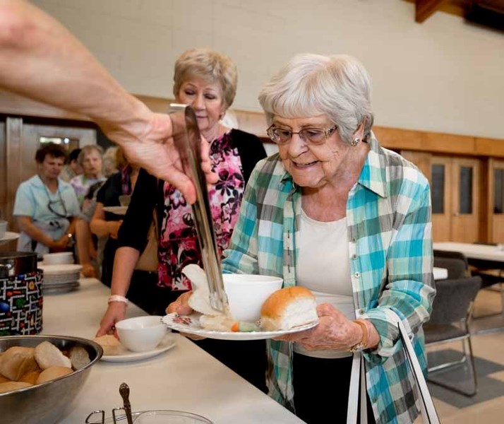 Enid Pettifer gets some chips during the free community lunch at St. Andrew&#8217;s United Church in Cochrane on Tuesday, May 30, 2017. Everyone is welcome for the free