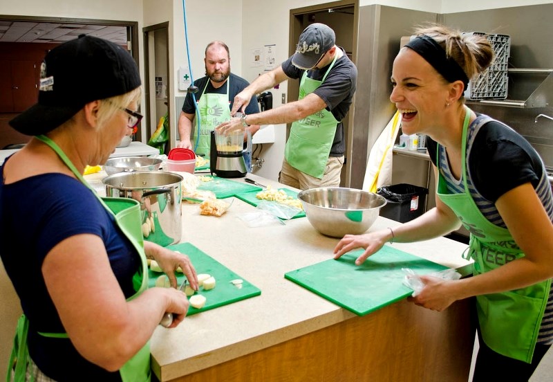 Paula Defries (right) has a laugh with Julie Bromley (left) during their Meal Team volunteering on Sunday at the Seniors on the Bow Centre. The team of eight made