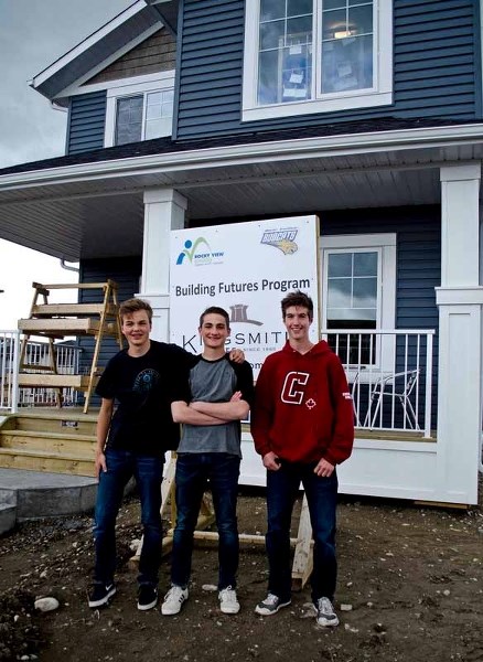 Cochrane High students Lewis Wharmby, 15, Max Roussel, 17, and Ben Mills, 16, proudly show off the house they build with other students from Bow Valley High and Springbank