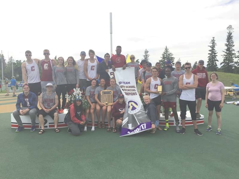 Cochrane High School athletes pose with the ASAA provincial track and field banner.