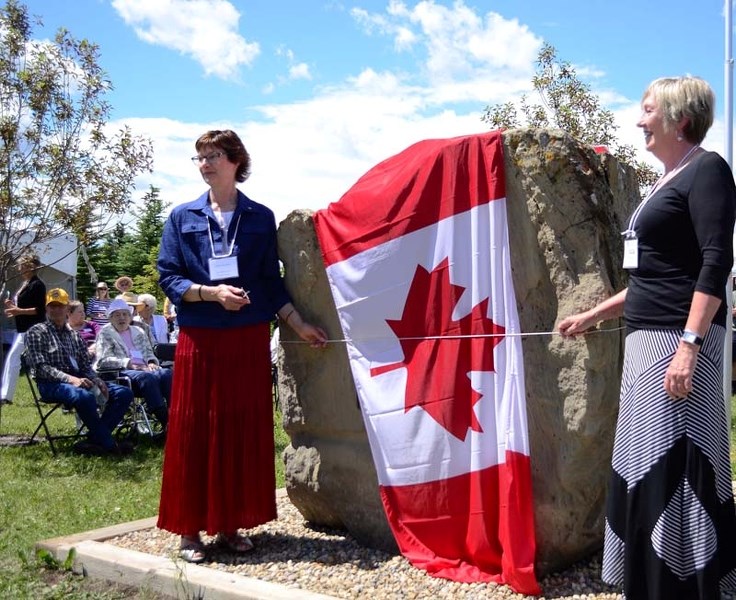 Community Centennial Queen Anne Wearmouth and Princess Judy Bancroft unveil the Bearspaw Homesteaders Rock at the unveiling ceremony on June 24 at the Bearspaw Historical