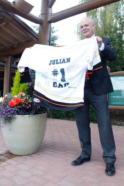 Following 22 years of service as Chief Administration Officer for the Town of Cochrane, Julian de Cocq was presented with a jersey on behalf of town council and