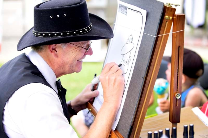 Garry W. Peck creates a caricature for a family during Bragg Creek Days on July 23. RYAN MCLEOD/COCHRANE EAGLE