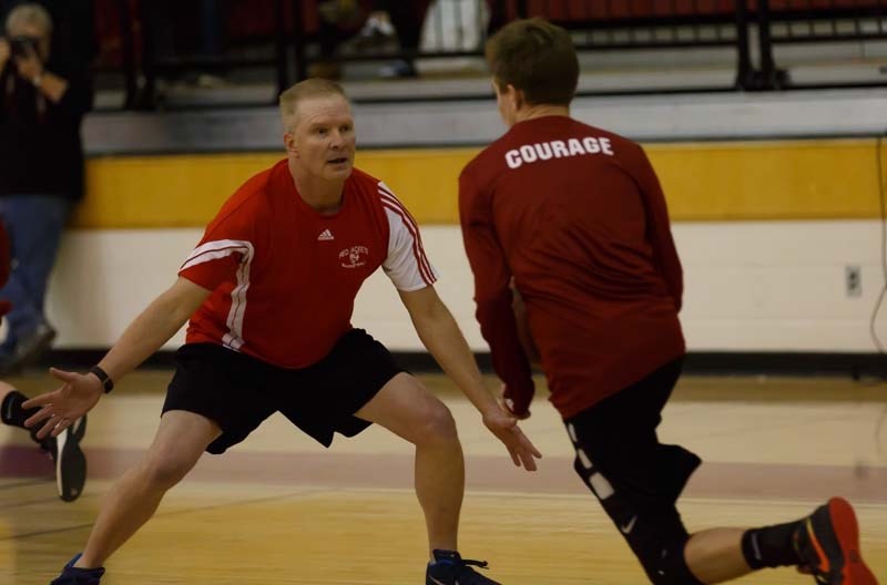 Randy Peron, left, tries to block the ball against a student durning the student teacher basketball game on March 24.