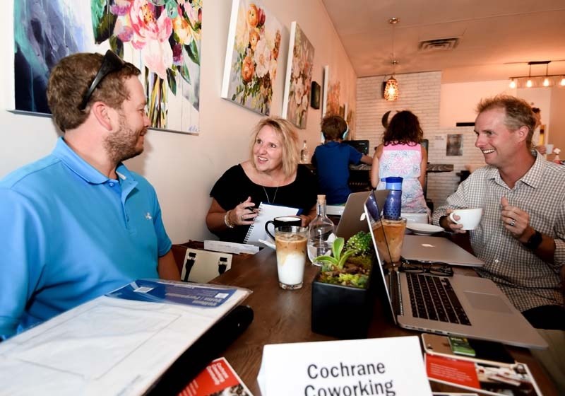 Catherine Gardiner chats with Jesse Davidson, left, and Mark Eaton during the Cochrane Co-working Meetup at the Gentry Expresso and Wine Bar in Cochrane on Tuesday.