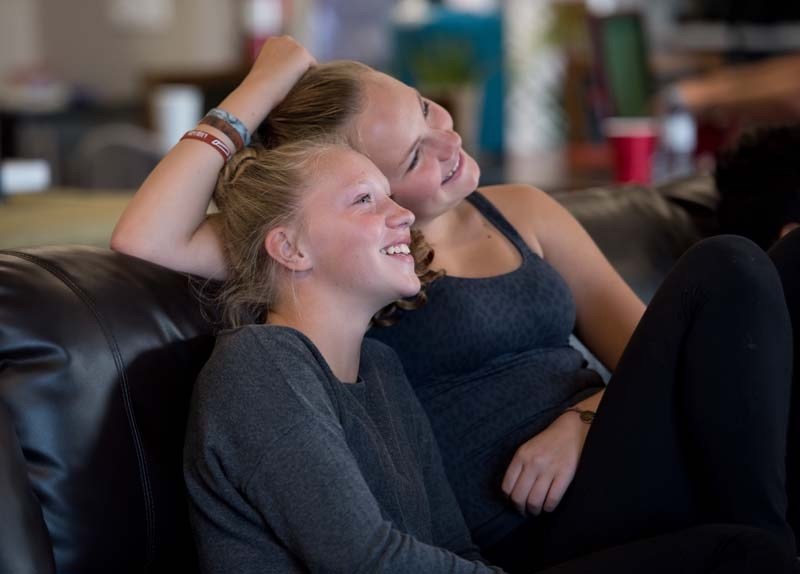 Sara, left, and Brea watch Alvin and the Chipmunks during the Leaders in Training program wrap-up party at the Boys and Girls Club of Cochrane and Area on Friday.