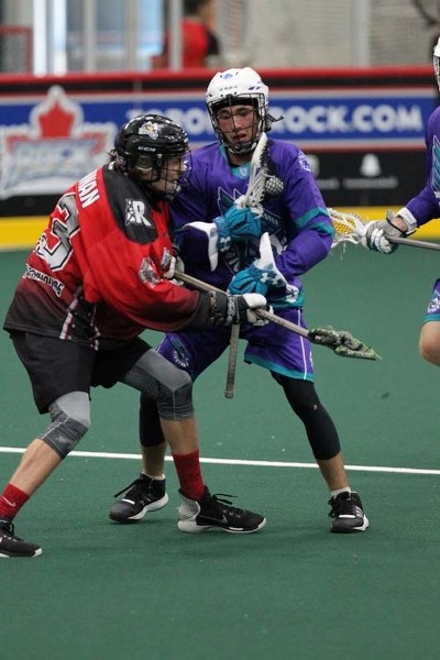 Local Cochrane teen Nick Drennan fends off a Knighthawks defender.