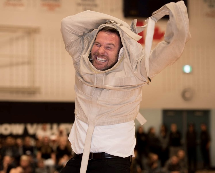 Scott Hammell works to free himself from a straitjacket.