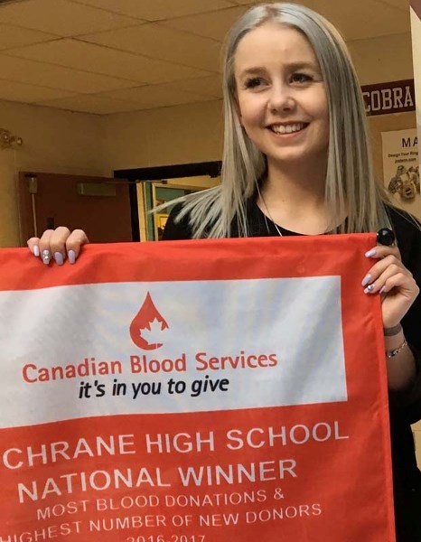 Tailleur Oulton holds the banner Cochrane High School won for donating the most blood in the country for the Give Life National High School Blood Challenge.