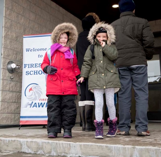 Students Lyla, left, and Brynn Hayward head home after their first day at the new Fireside School in Cochrane on Tuesday, Nov. 14, 2017.