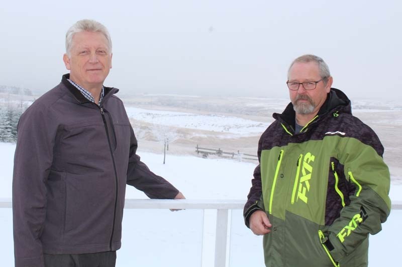 John Groenvald (left) and Bruce Rasmussen stand on Groenvald&#8217;s balcony, overlooking the future development of Sunset Ridge just beyond Groenvald&#8217;s property line.