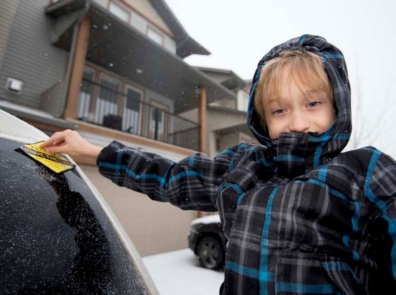 Riverview Community resident Xavier Menssa, 8, sticks a cautionary speed decal on his family&#8217;s van.