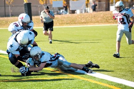 Cochrane Lions receiver Evan Perrault seals the deal in the final play of the game against Calgary Cowboys Navy in Calgary Bantam Football Association play Sept. 29 at