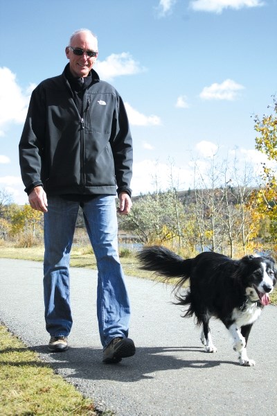 John Cook takes his best friend Jessie for a warm fall day walk at the Cochrane off-leash dog park along the Bow River Oct. 5.