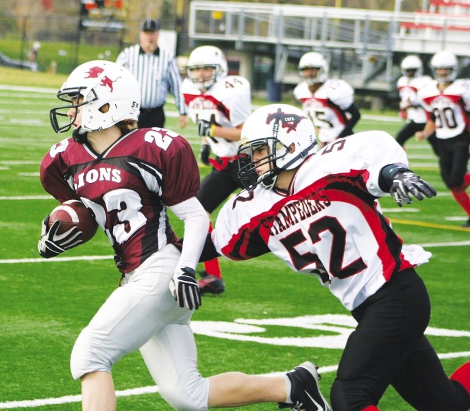 Cochrane Lions running back Tae Gorden is pursued by Calgary Stamps defender Julian Croft-Ramos Oct. 13 at Calgary&#8217;s Shouldice Park.