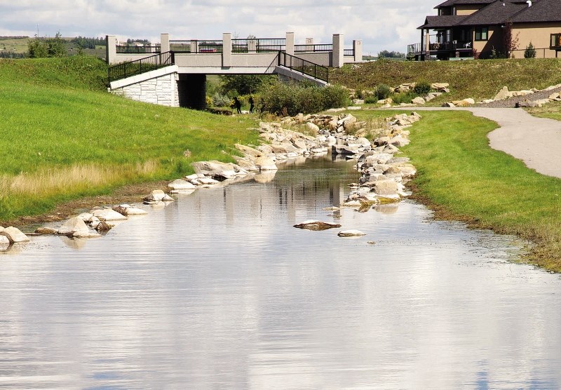 Water overflows the banks at the MonTerra on Cochrane Lakes neighbourhood during the month of August.