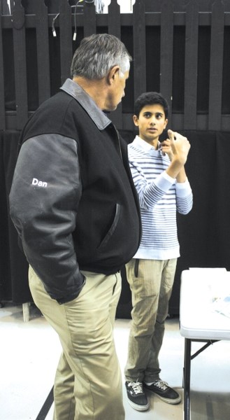 Cochrane High School (CHS) sustainability development committee member Ashish Sharma (right) talks to Cochranite Dan Muhlbach about the proposed Evance 9000 5kW small wind