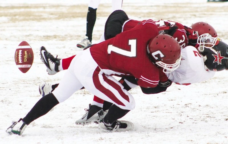 Cochrane High School (CHS) Cobras linebacker Mac Chaisson (7) and defensive back Travis Colleaux slam Chestermere High School Cowboys receiver Ali Abdulghani to the ground in 