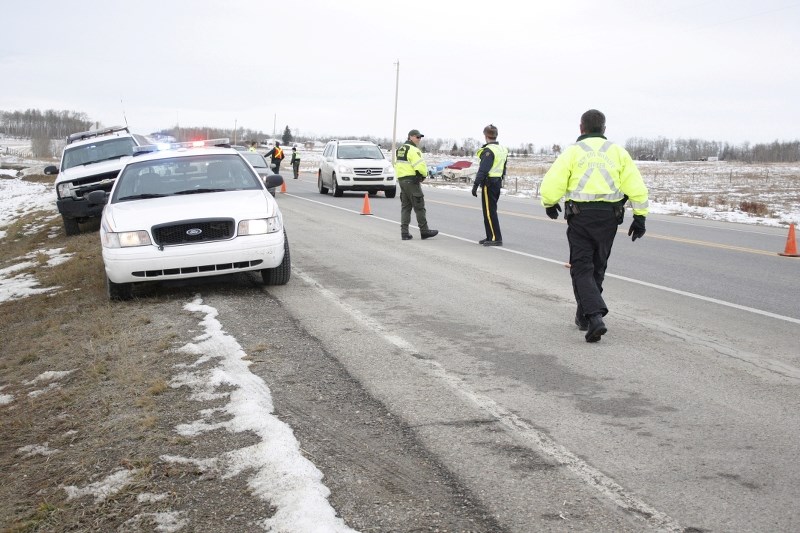 Alberta Fish and Wildlife officer Stan Hawes walks toward fellow Alberta Fish and Wildlife officer Rob DiPalo and Cochrane RCMP Const. Jason Ellison during a Nov. 4 afternoon 