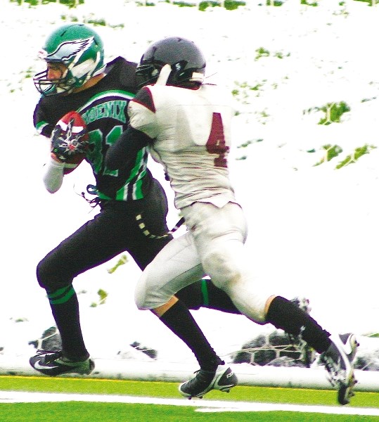 Springbank Community High School Phoenix receiver Kevin Natenstedt shakes the tackle of Foothills Composite High School Falcons defensive back Josh Koshman.