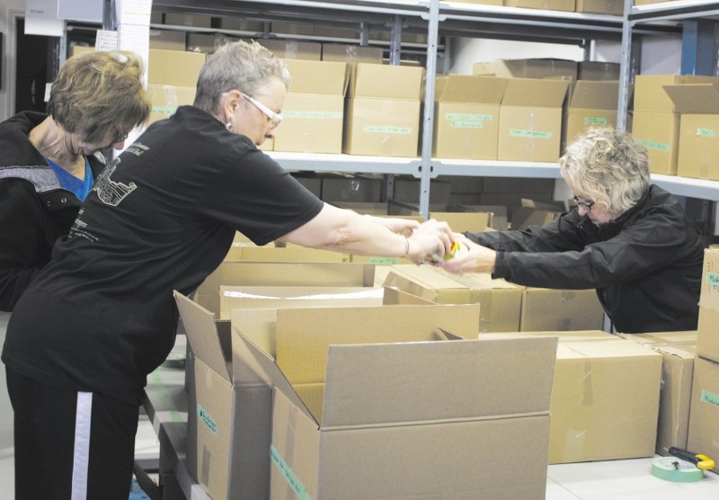 From left: Activettes Letty Polluck, Liz Maher and Pat Kulyk sort canned items into their respective boxes at the Activettes Food Bank on Nov. 15.