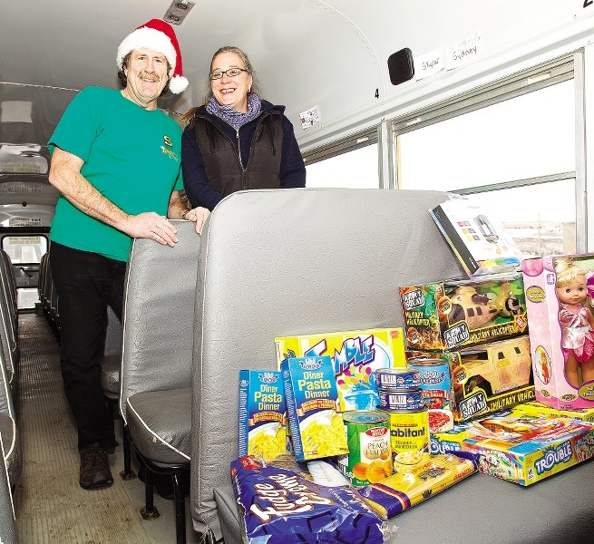 Brock Smith from Southland and Betty Anne Jansen from the Cochrane and Area Events Society pose for a photo to help promote the Dec. 3, 2011 &#8216;Stuff-A-Bus&#8217; event