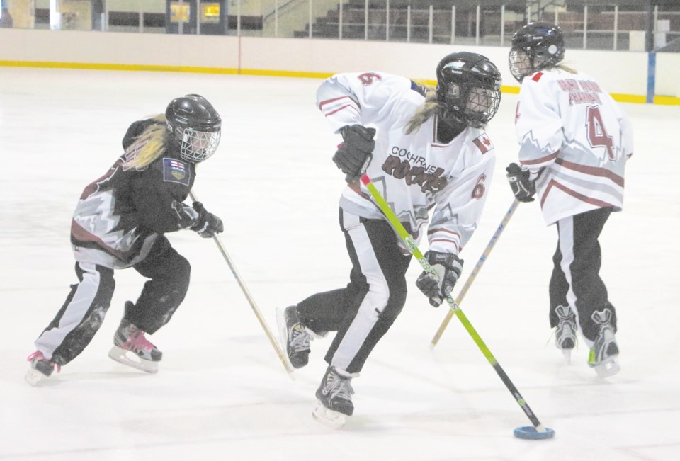 Cochrane Rockies U16 Rovanna Irvin pursues Nicole Cantor as Brooklyn Bolstad clears the zone