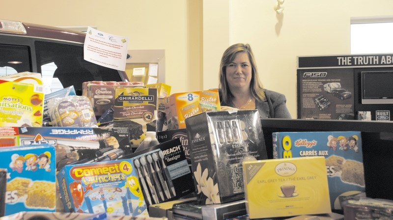 North Star Ford Cochrane sales manager Bridget Calvank proudly displays the goodies donated to the dealership&#8217;s Fill A Truck campaign. All donations will be given to