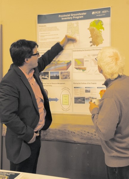 Corey Froese of the Energy Resources Conservation Board, left, explains a province-wide groundwater program to a Rocky View County resident at an information session held at