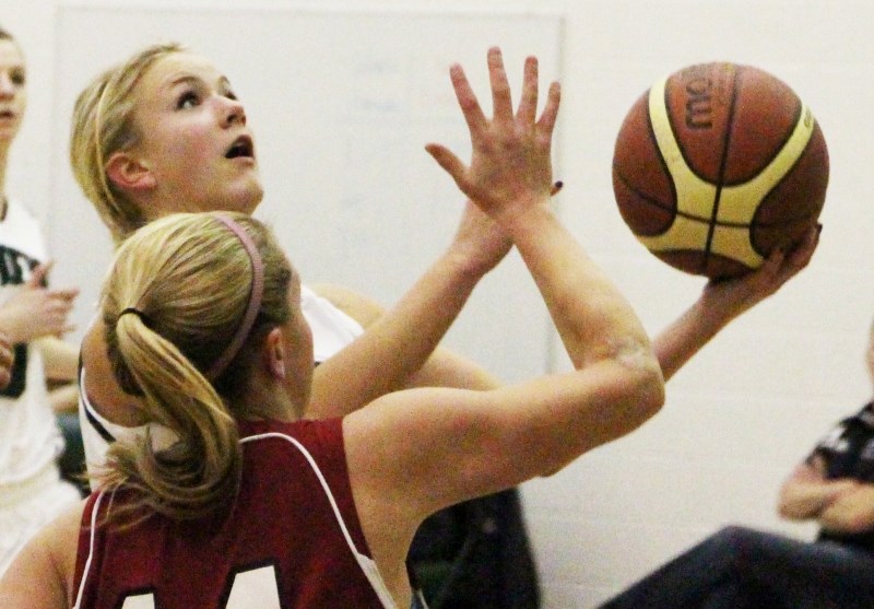 Springbank Community High School Phoenix Maya Parker goes up for a basket while Cochrane High School Cobras&#8217; Angela Lowe defends in Rocky View Sports Association