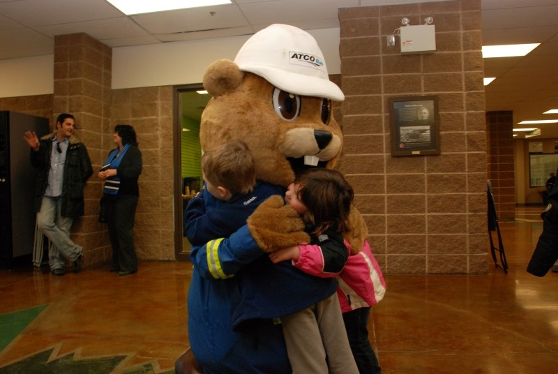 Ashtynn Forsberg and Tanner Godard, both four years old, give Digger the ATCO Gas prairie dog a hug during an ATCO Gas Cochrane WinterFest press conference at Spray Lake
