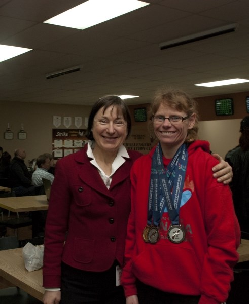 Elouise Stewart, Cochrane&#8217;s cross-country skier, proudly displays her medals alongside her mother, Laura Kowalsky, at Cochrane Lanes during a meet up with the Cochrane
