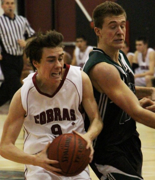 Cochrane High School Cobras&#8217; Murray Perrault drives into the paint while being guarded by Springbank Community High School Phoenix John Proppe in Rocky View Sports
