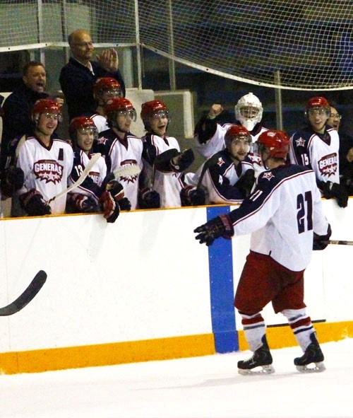 Cochrane Generals forward Kris Keller (left) is greeted at the bench after the Generals put the third and deciding game of the Heritage Junior Hockey League opening-round