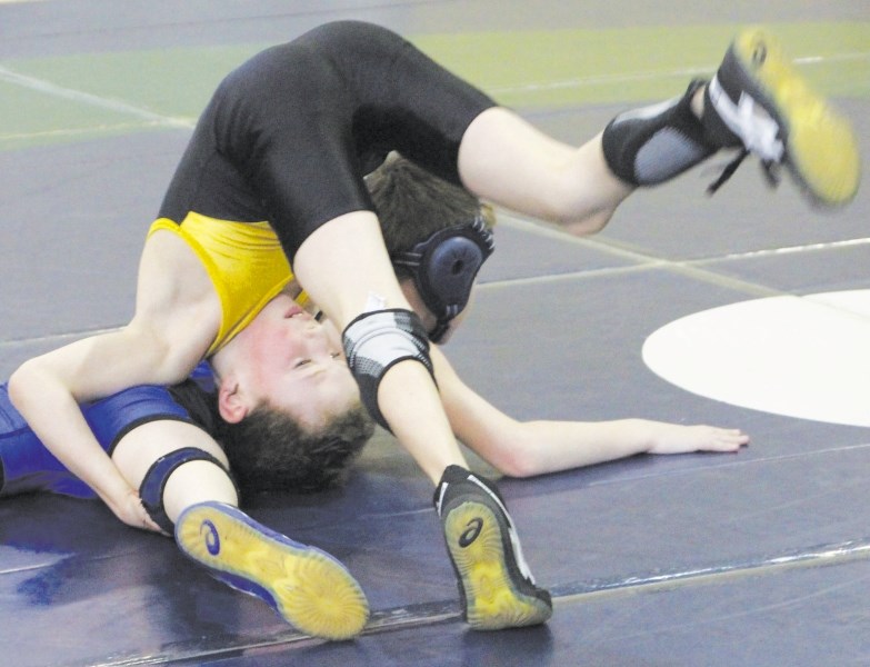 Cochrane Cowboys wrestler Keath Dostaler goes upside down to get the upper hand against Edmonton&#8217;s Logan Kennedy during the Western Canadian Youth Wrestling