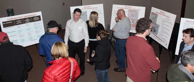 Mike Korman, economic development manager for the Town of Cochrane, centre, white shirt, speaks with residents during the transit alternatives open house on March 6 at the