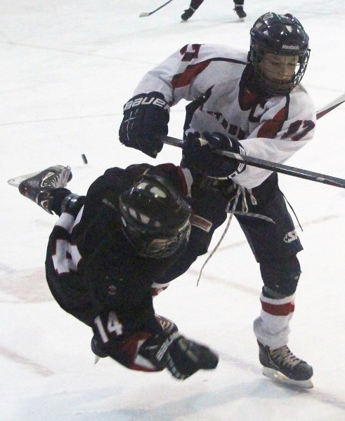 Lethbridge Giants&#8217; Gunner Kinniburgh knocks Bow Valley Timberwolves&#8217; Ethan Strang to the ice with a stiff body-check in South Central Alberta Hockey League Peewee 