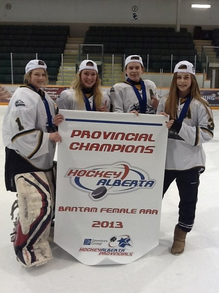 Cochranites (from left) Amanda Zeglen, Taylor Sawka, Brette Matheson and Nicolette Seper show off the provincial championship banner their Rocky Mountain Raiders won March 23 