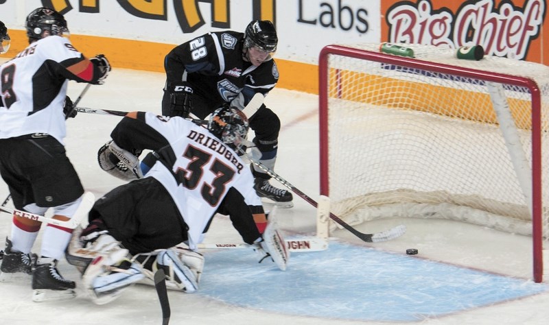 Cochrane&#8217;s Coda Gordon of the Swift Current Broncos scores on Calgary Hitmen goalie Chris Driedger in Western Hockey League playoff play March 21 in Calgary. The Hitmen 