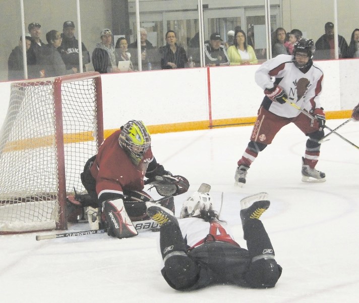 Stoney Nakoda&#8217;s Ayla Hunter dives for a rebound against Maskwacis goalie Mia Buffalo during Alberta Treaty Hockey Championships midget girls consolation-final action