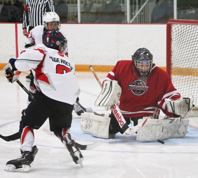 Foothills goalie Anderson Violette of Cochrane eats up a shot from Calgary Rage forward Ryan Sullivan in Foothills Elite Peewee AAA Spring Ice Breaker hockey tournament play