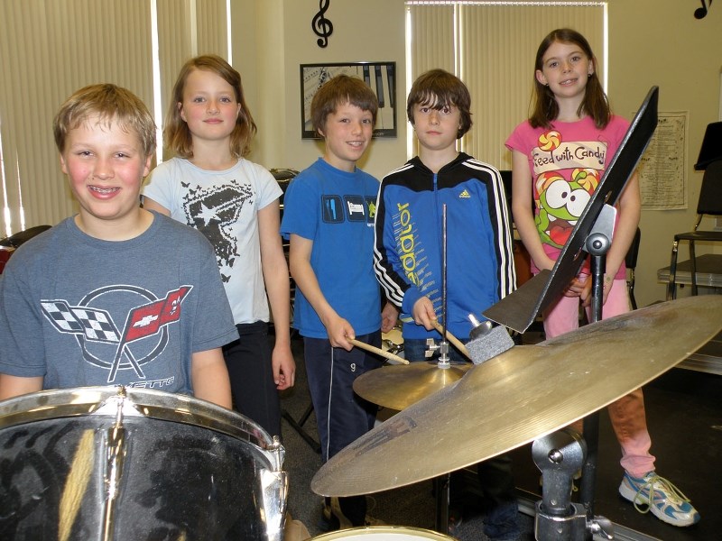 Banded Peak School music students Coy Neumeister, Sonya Urbanowicz, Cyrus Urbanowicz, Thijs van Lankvelt, and Ahneke van Lankvelt, prepare to perform the song